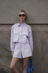 a lady wears a light purple crop jacket and matching shorts